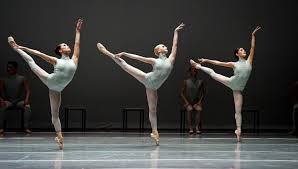 Three Boston Ballet ballerinas arabesque on pointe