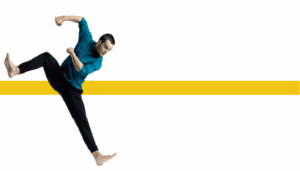 Dancer lifts right leg with both feet flexed and bends both arms towards the right leg in an off balance position