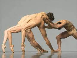 Three dancers lunge over their left pointed toes while pulling a fourth dancers arms. All four dancersa wear nude tight costumes.