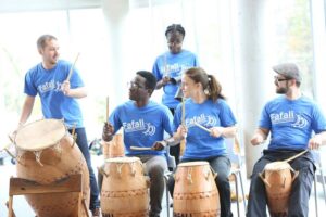 Fafali group in blue matching t-shirts playing their drums.