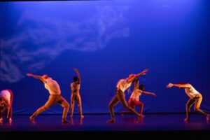 Salem Dance Ensemble performance photo with dancers on stage hinging forward and bak with one arm over head.