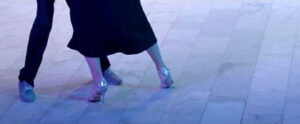 Cropped photo of two people dancing tango so only lower half of legs are visible.