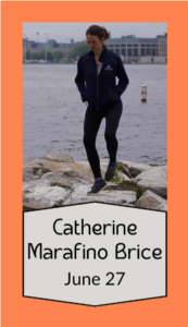 Catherine Marafino Brice, wearing black, her hands in her pockets, does footwork on a rock in front of a bay