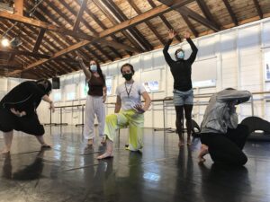 5 dancers pose in appear in different poses in a dance studio.