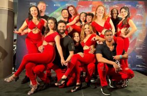 Bachata team with women in red and men in black.