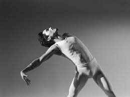 Black and white photo of Boston Ballet dancer hinged back and reaching arms back.