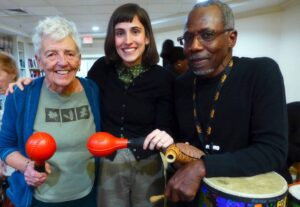 Photo of three people in different stages of life holding on to musical instruments.