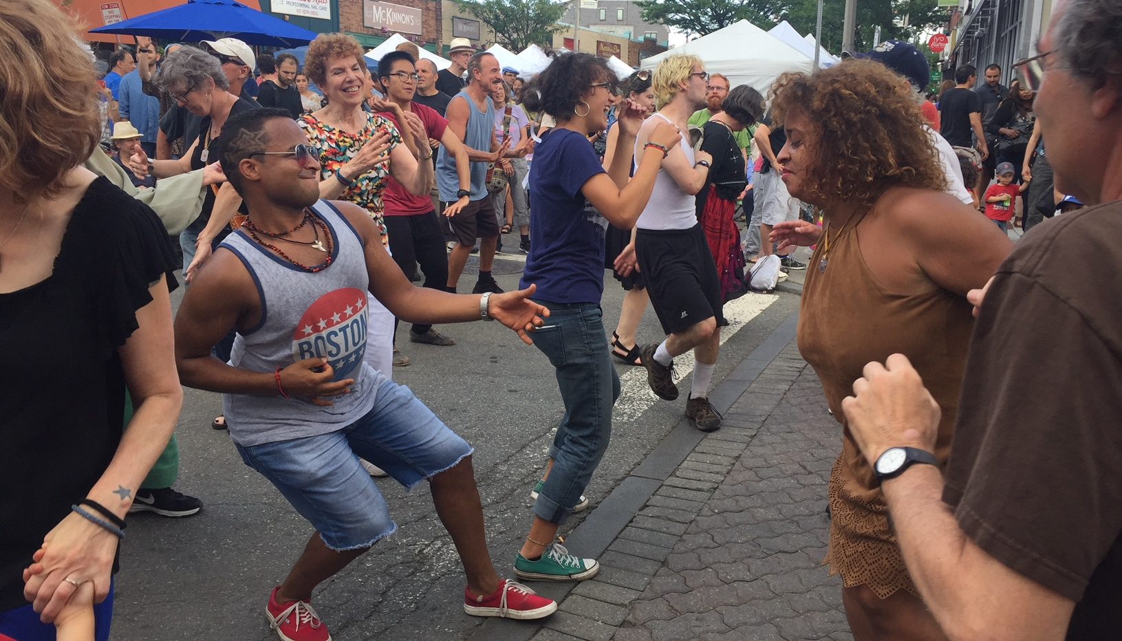 Photo of multiple people dancing in the streets.