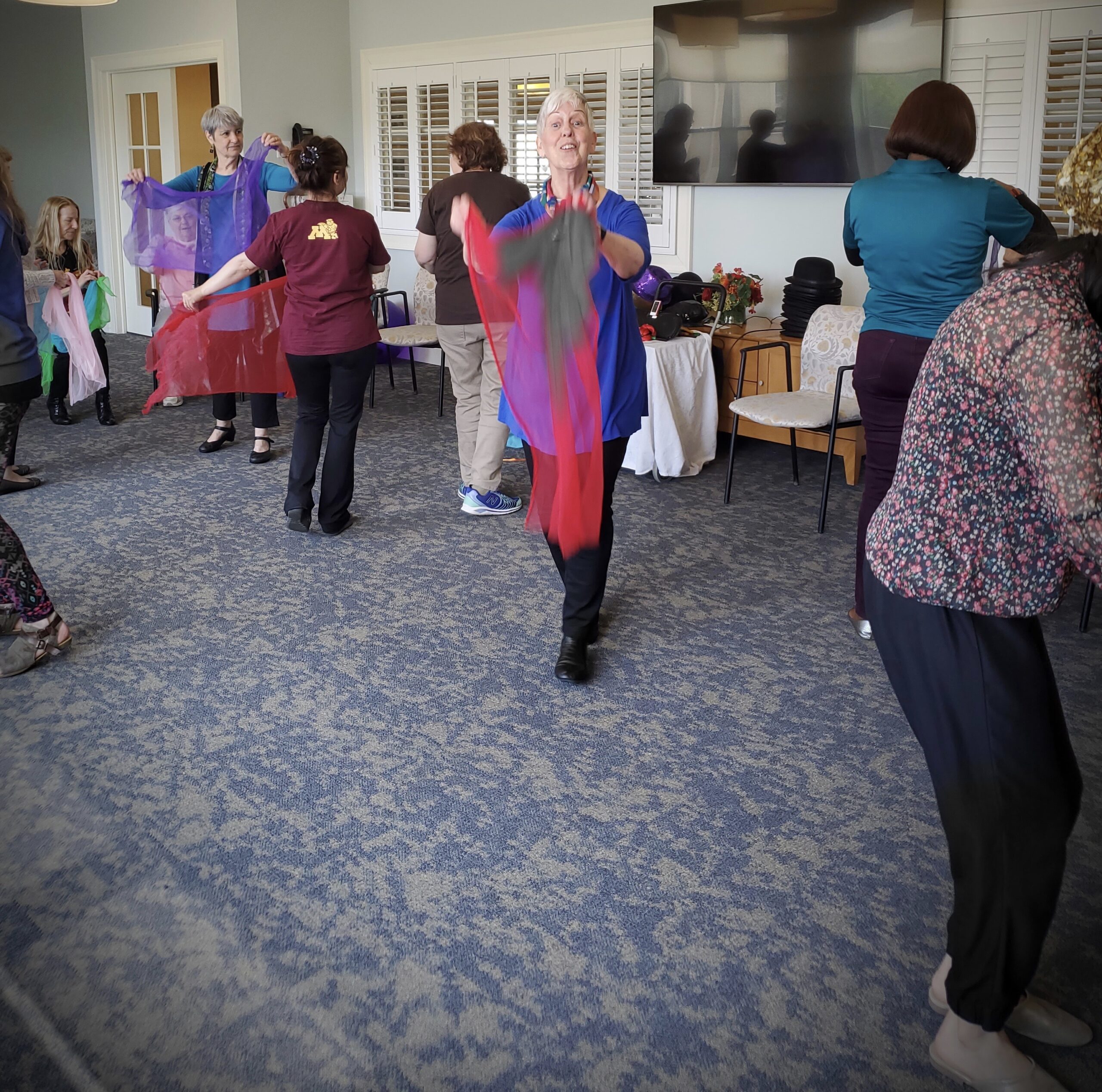 Trainees dance with people with dementia, sitting and standing.