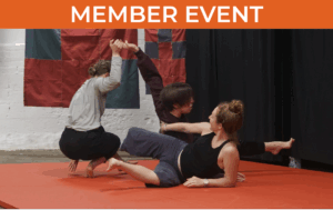 One dancer reclines on their side, extending an arm and leg outward. Another kneels close by, grasping the third dancer’s raised hand.