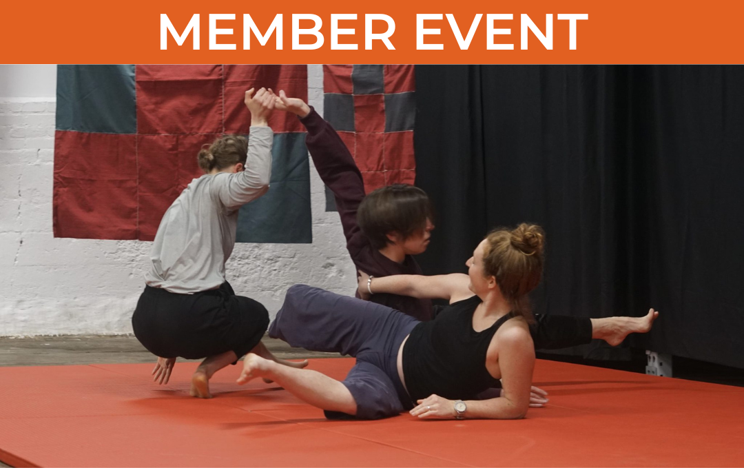 One dancer reclines on their side, extending an arm and leg outward. Another kneels close by, grasping the third dancer’s raised hand.
