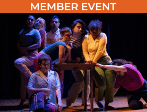 Group of dancers sitting on or in front of a wooden table