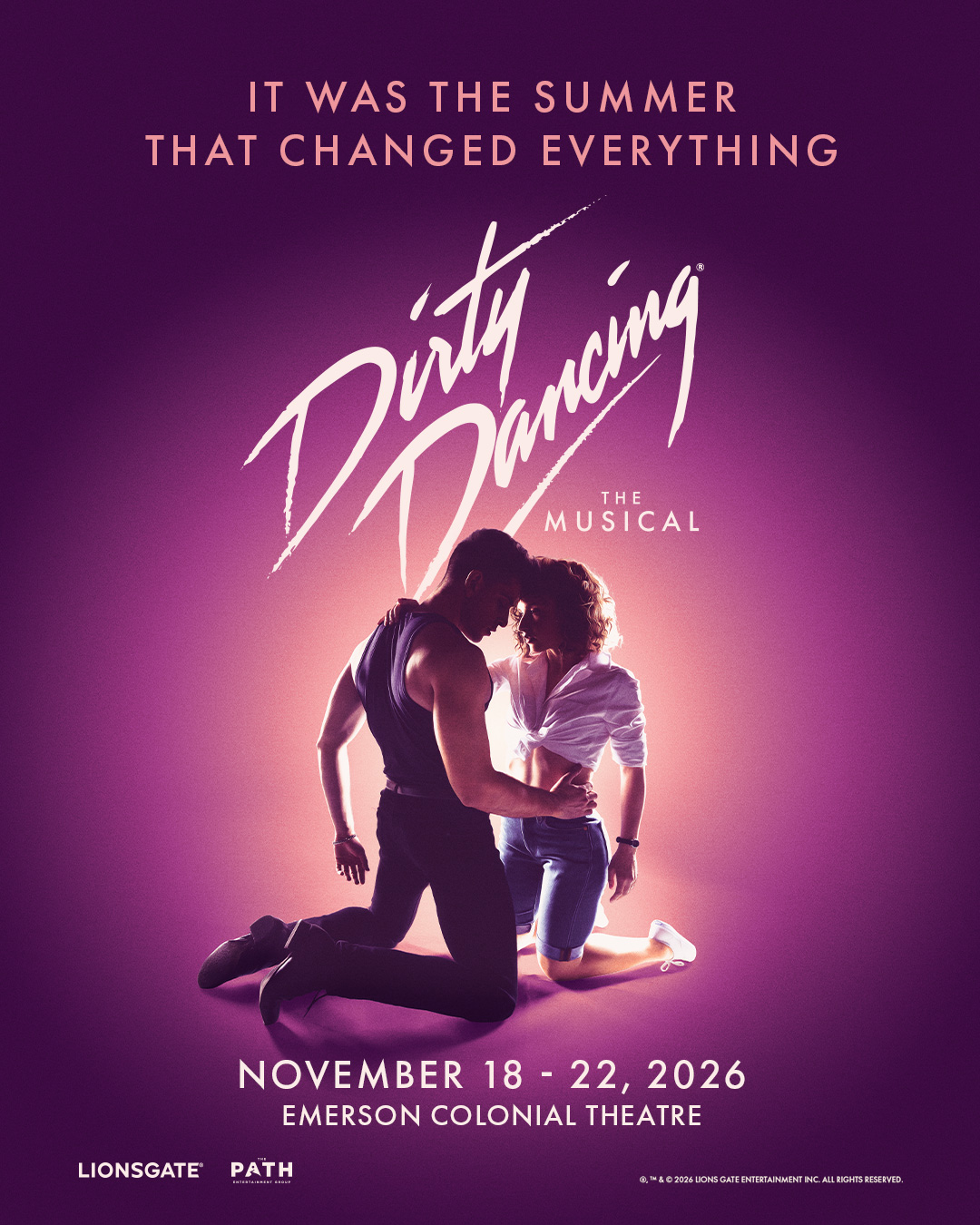 Poster for Dirty Dancing: The Musical. A man in a dark tank top and a woman in a knotted white shirt and denim shorts kneel facing each other, foreheads touching, against a glowing pink-and-purple background. Text reads “It was the summer that changed everything.” Performances November 18 to 22, 2026, at Emerson Colonial Theatre.